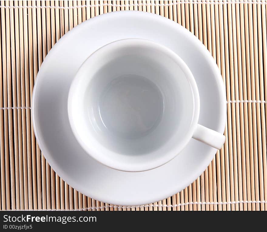 White cup on bamboo background from above