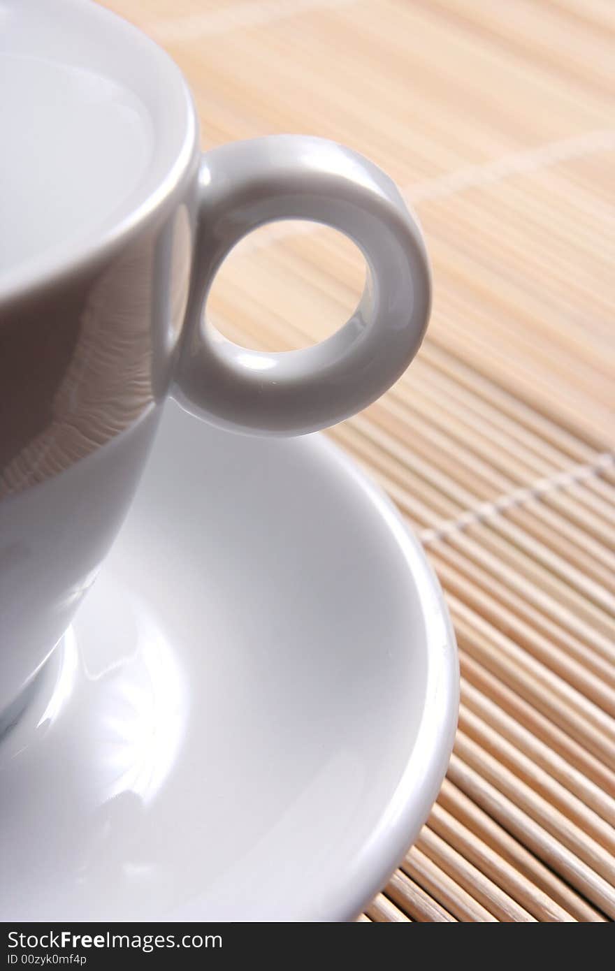 White cup on bamboo mat -background