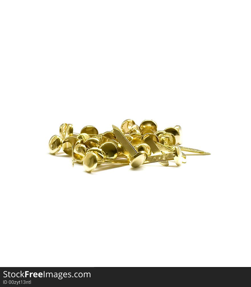 A collection of brass pins scattered against a white background. A collection of brass pins scattered against a white background