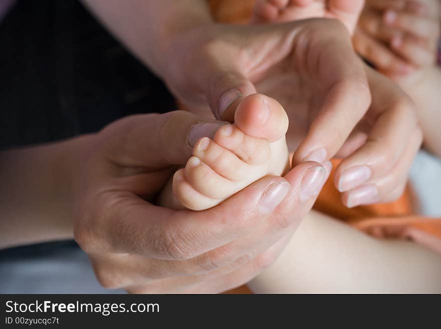 Baby foot is held by mother hands