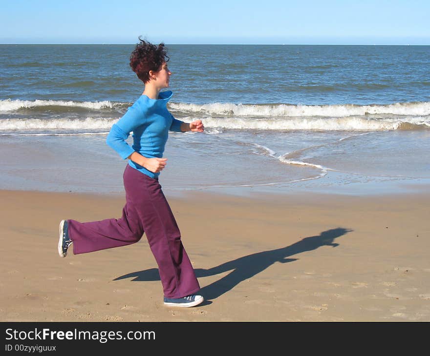 She is doing exersice on the beach. She is doing exersice on the beach.