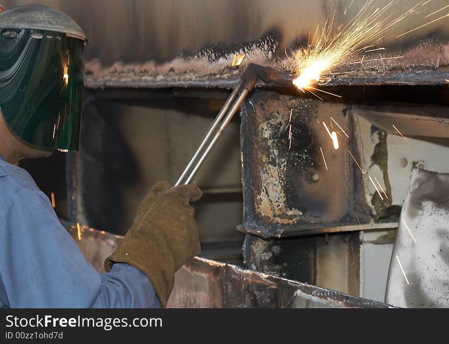 A welder working a torch at shipyard. A welder working a torch at shipyard