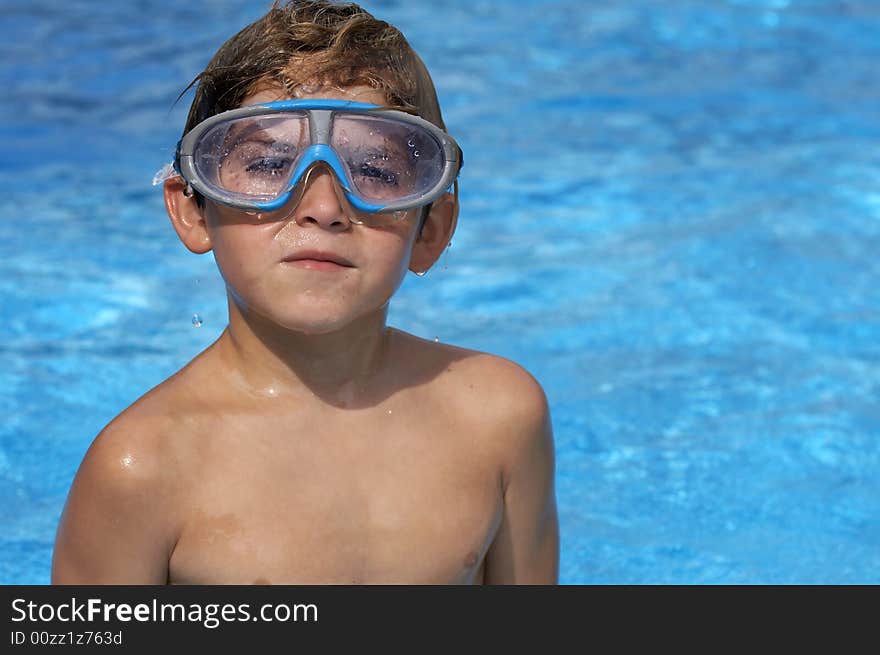 A young boy in pool with goggles on. A young boy in pool with goggles on