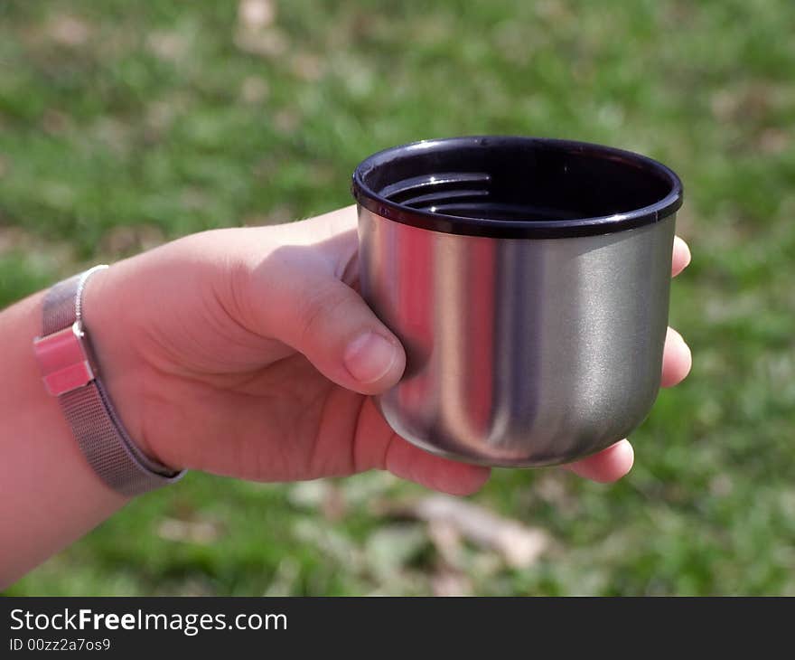 Cup in a hand during rest on walk on forest