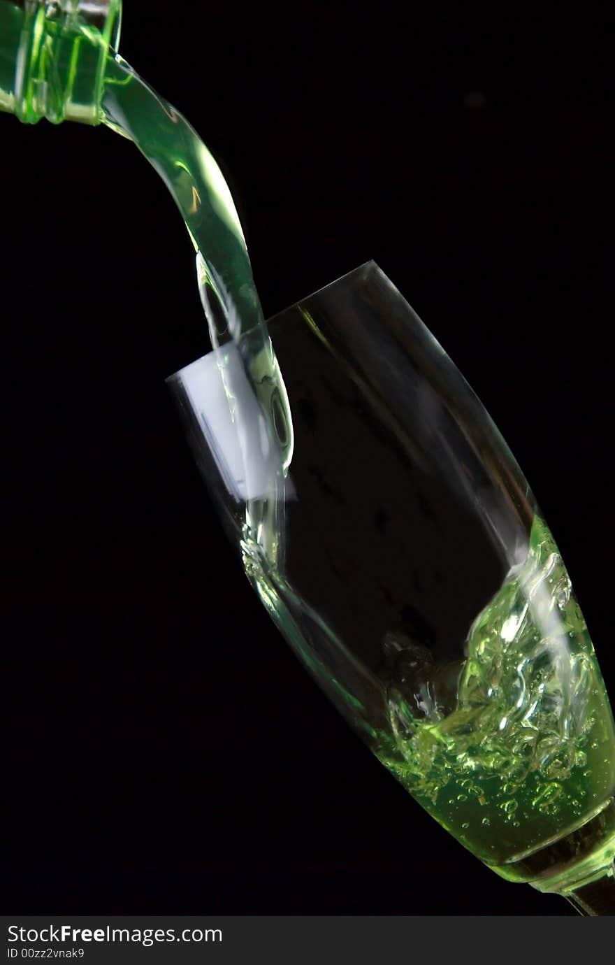 Glass of drink poured on black background