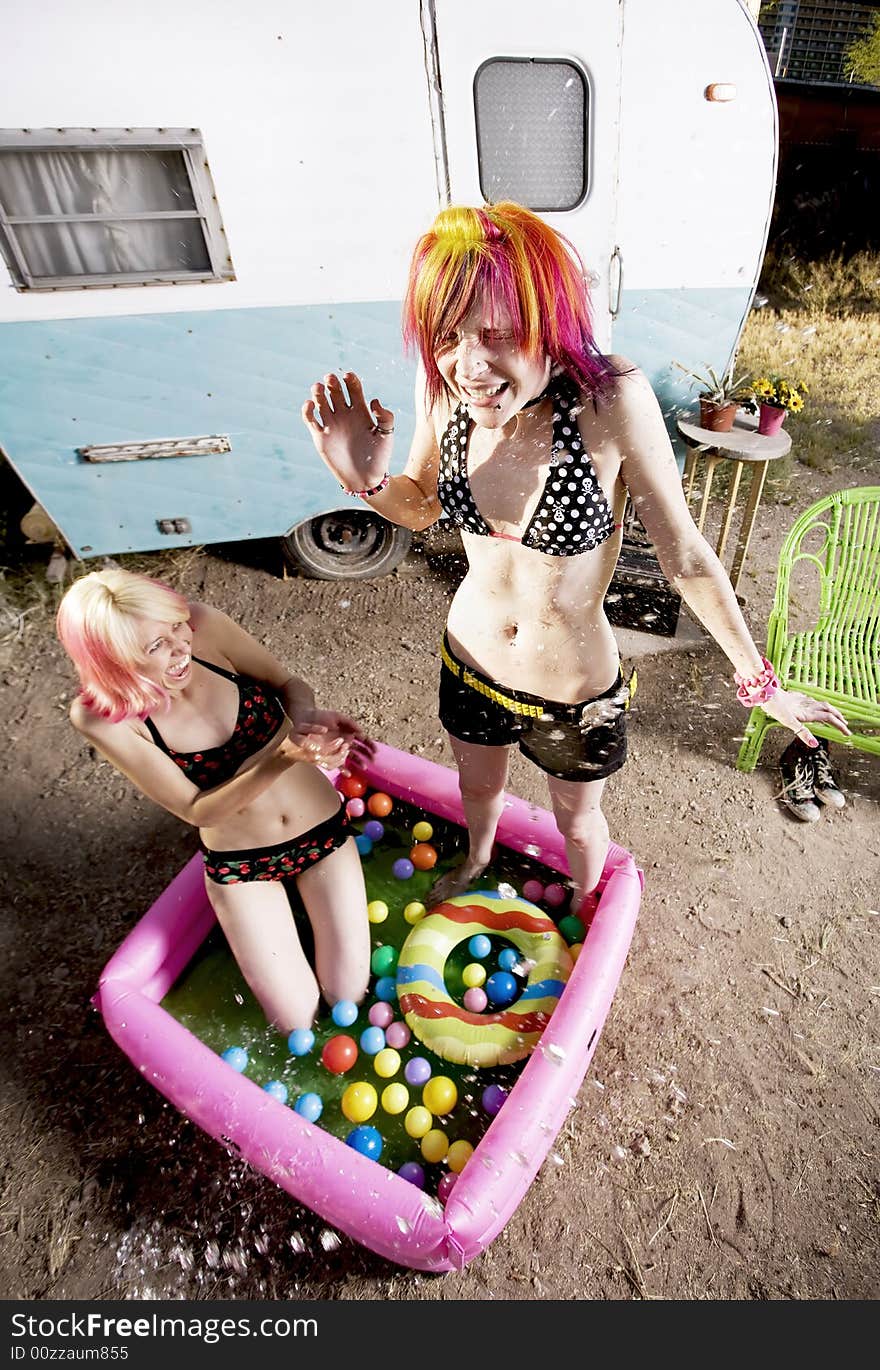 Colorful young women splashing in an inflatable play pool. Colorful young women splashing in an inflatable play pool