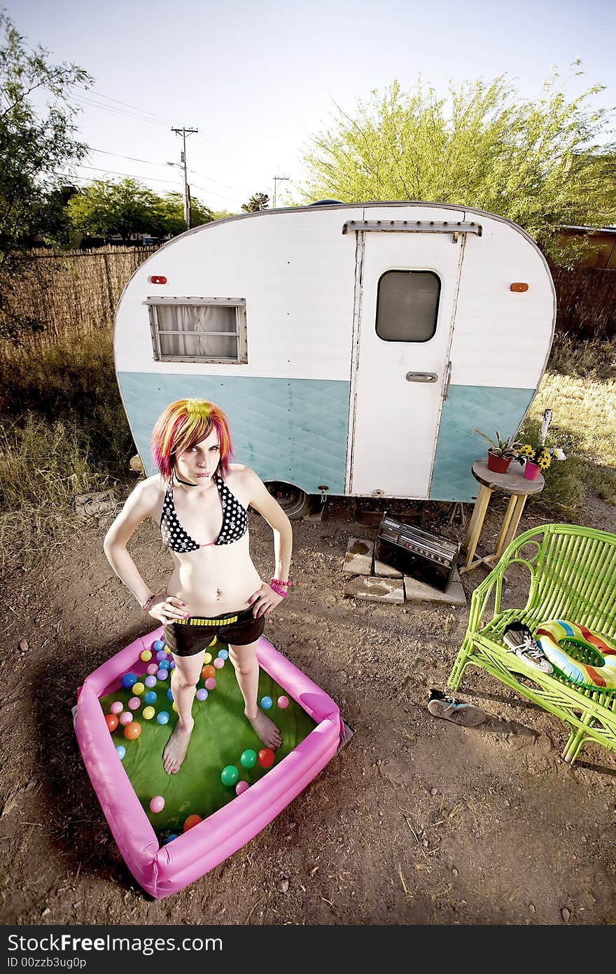 Woman standing in a play pool outside a trailer. Woman standing in a play pool outside a trailer