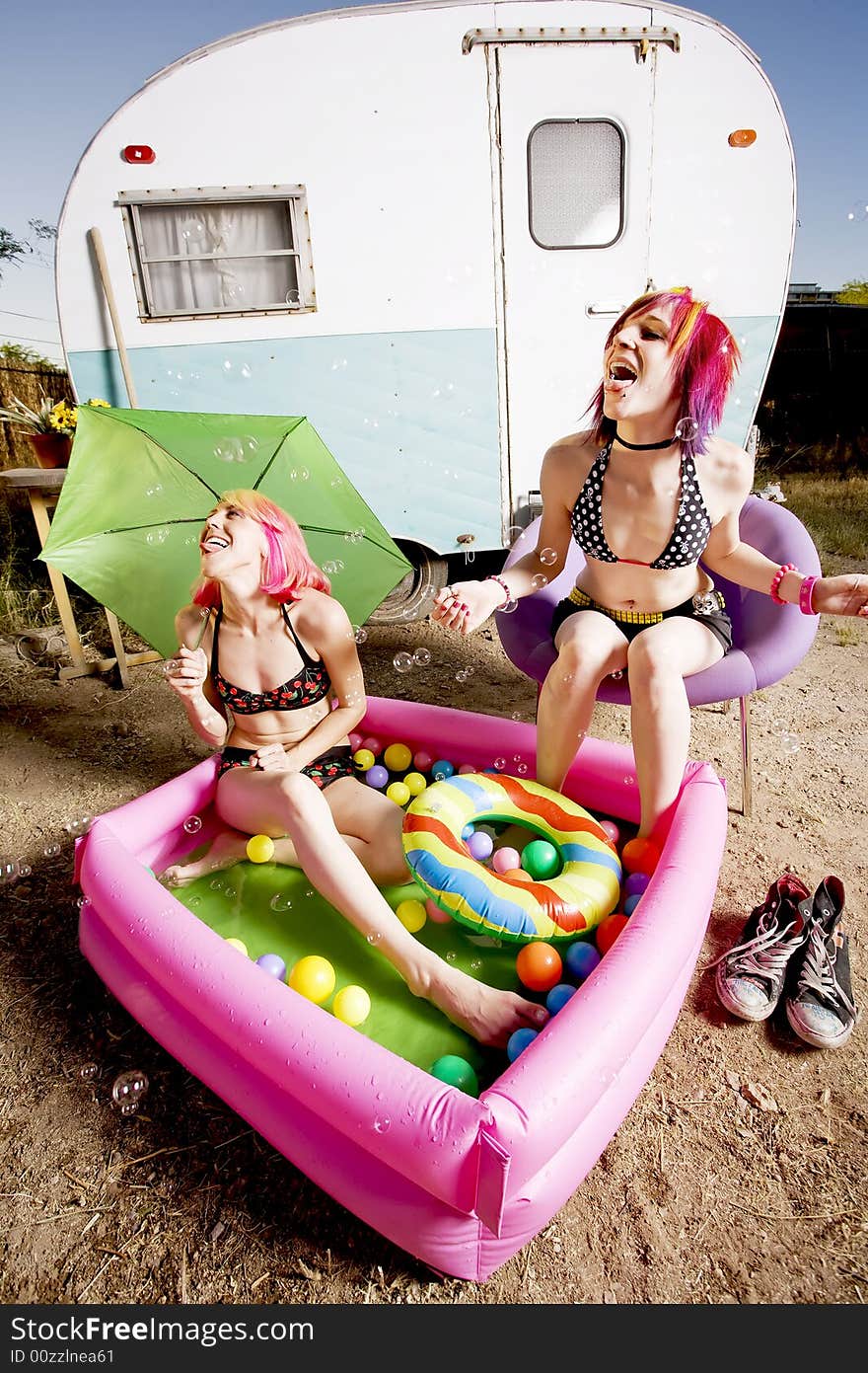 Woman with in an inflatable play pool playing with bubbles. Woman with in an inflatable play pool playing with bubbles