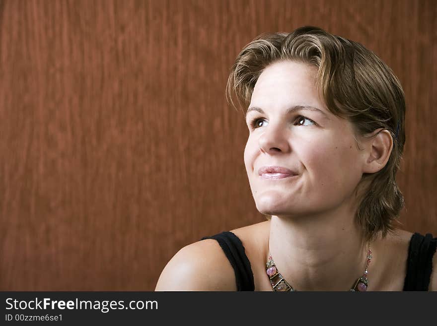 Woman wearing a necklace looking up to the left. Woman wearing a necklace looking up to the left