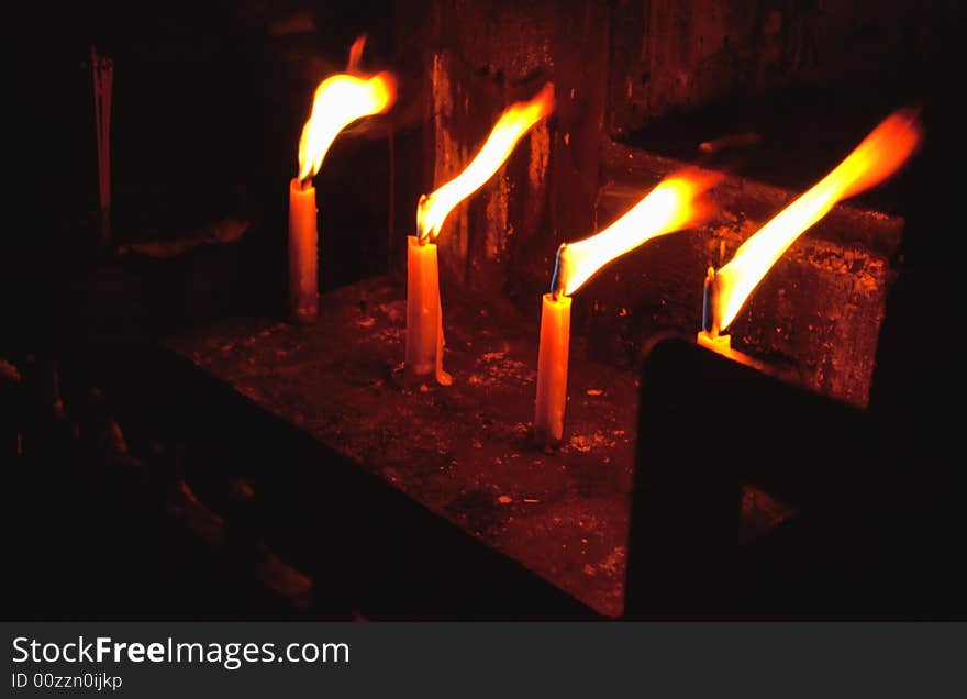 Blazing candle-flames in Buddhist temple in Chiang Mai, Thailand