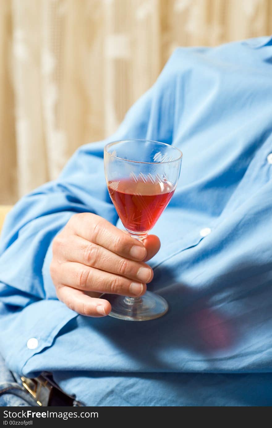 An abstract view of a man holding a wine glass. Vertically framed shot. An abstract view of a man holding a wine glass. Vertically framed shot.