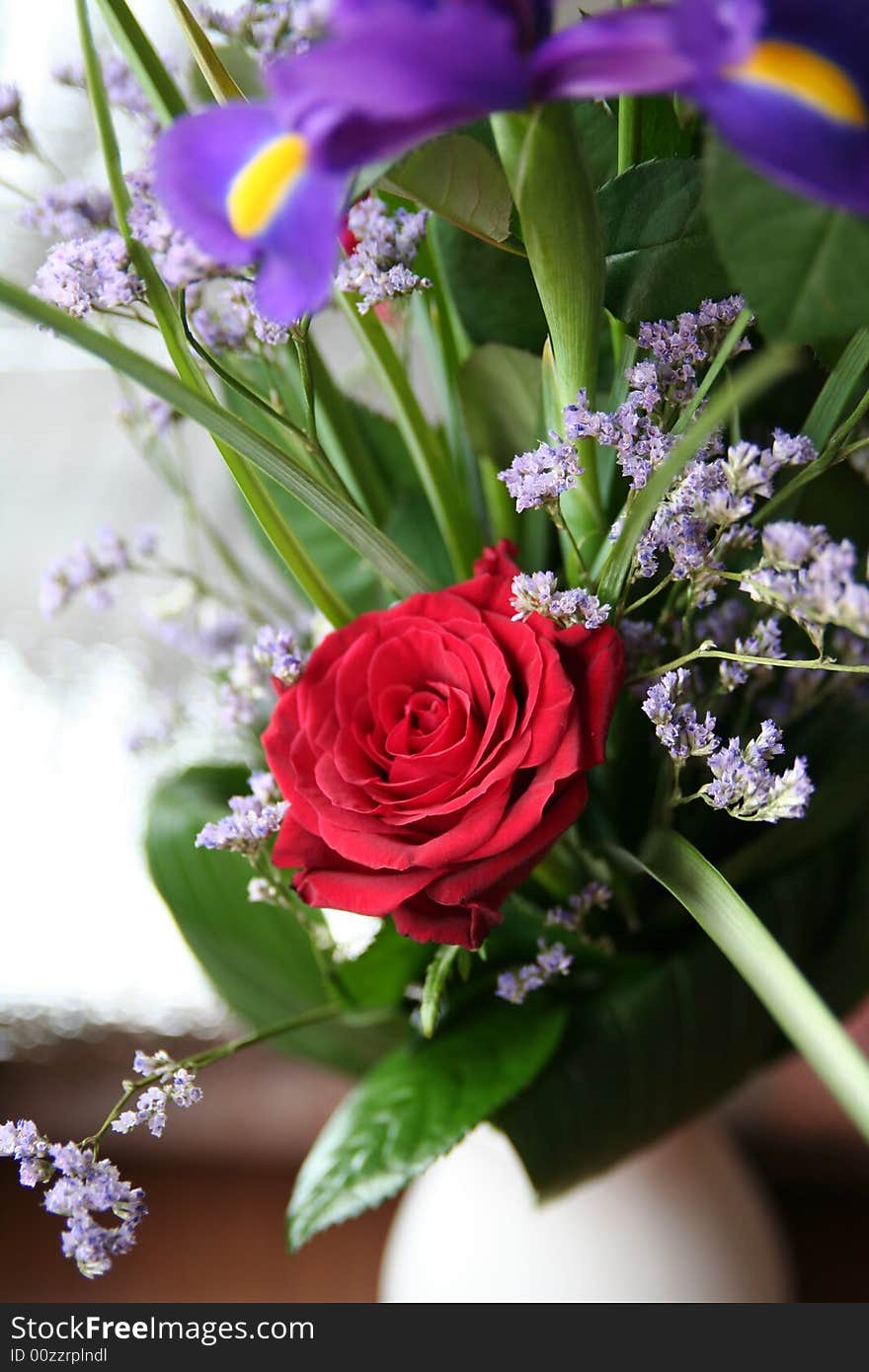 A bouquet with red roses and blue irises