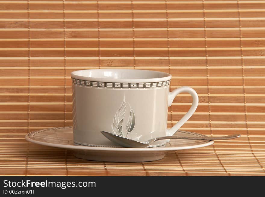 White cup of coffee on bamboo background