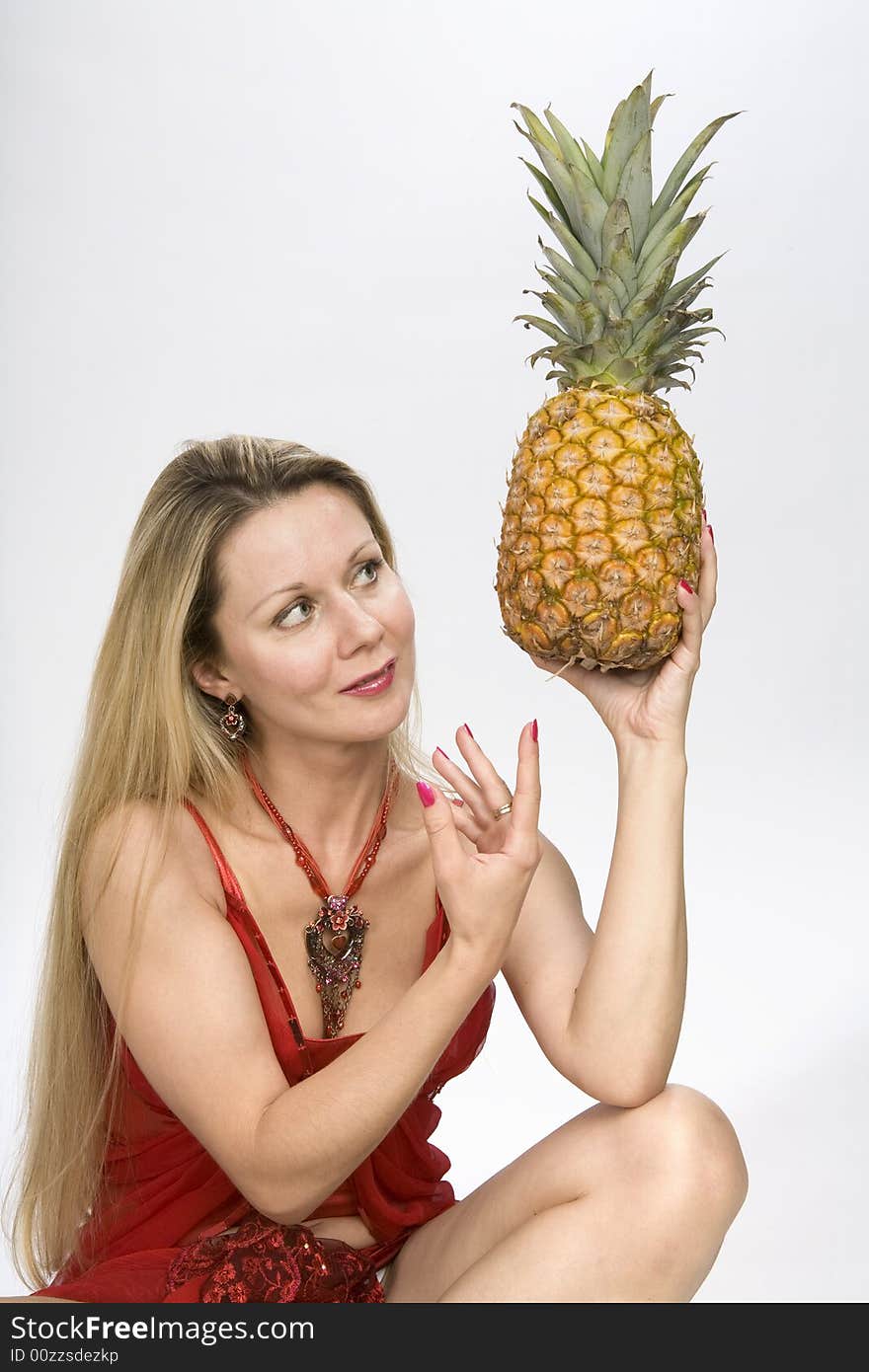 Blonde long hair woman with a pineapple in her hands. Blonde long hair woman with a pineapple in her hands