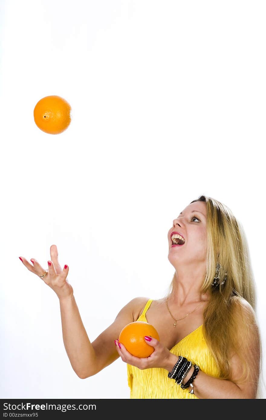 Blonde woman in yellow dress with two oranges. Blonde woman in yellow dress with two oranges