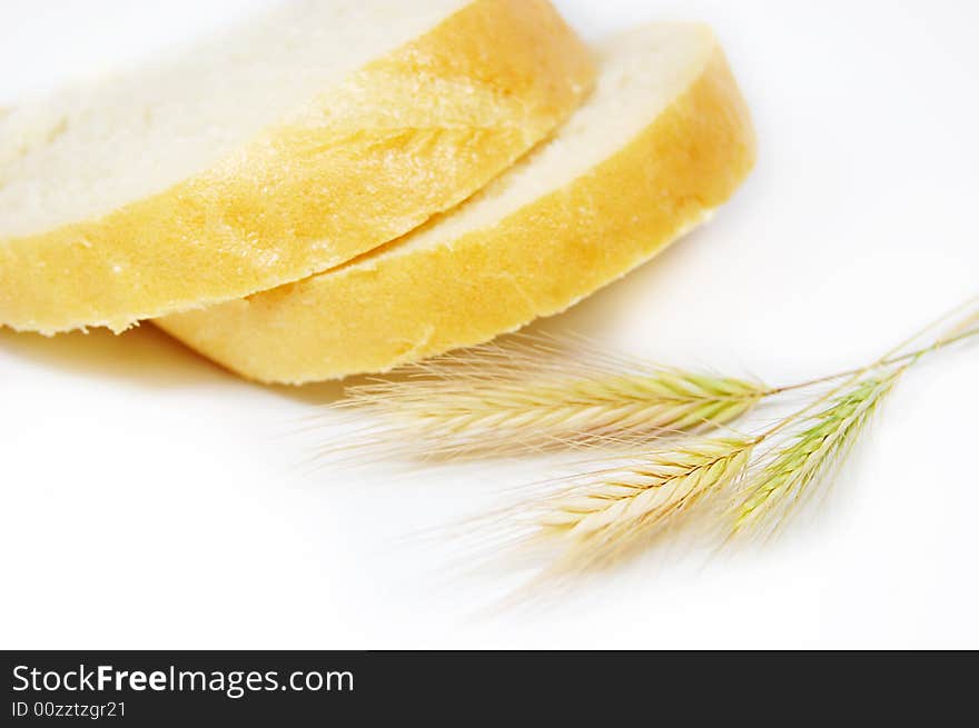 Some slices of bread and wheat corns on white