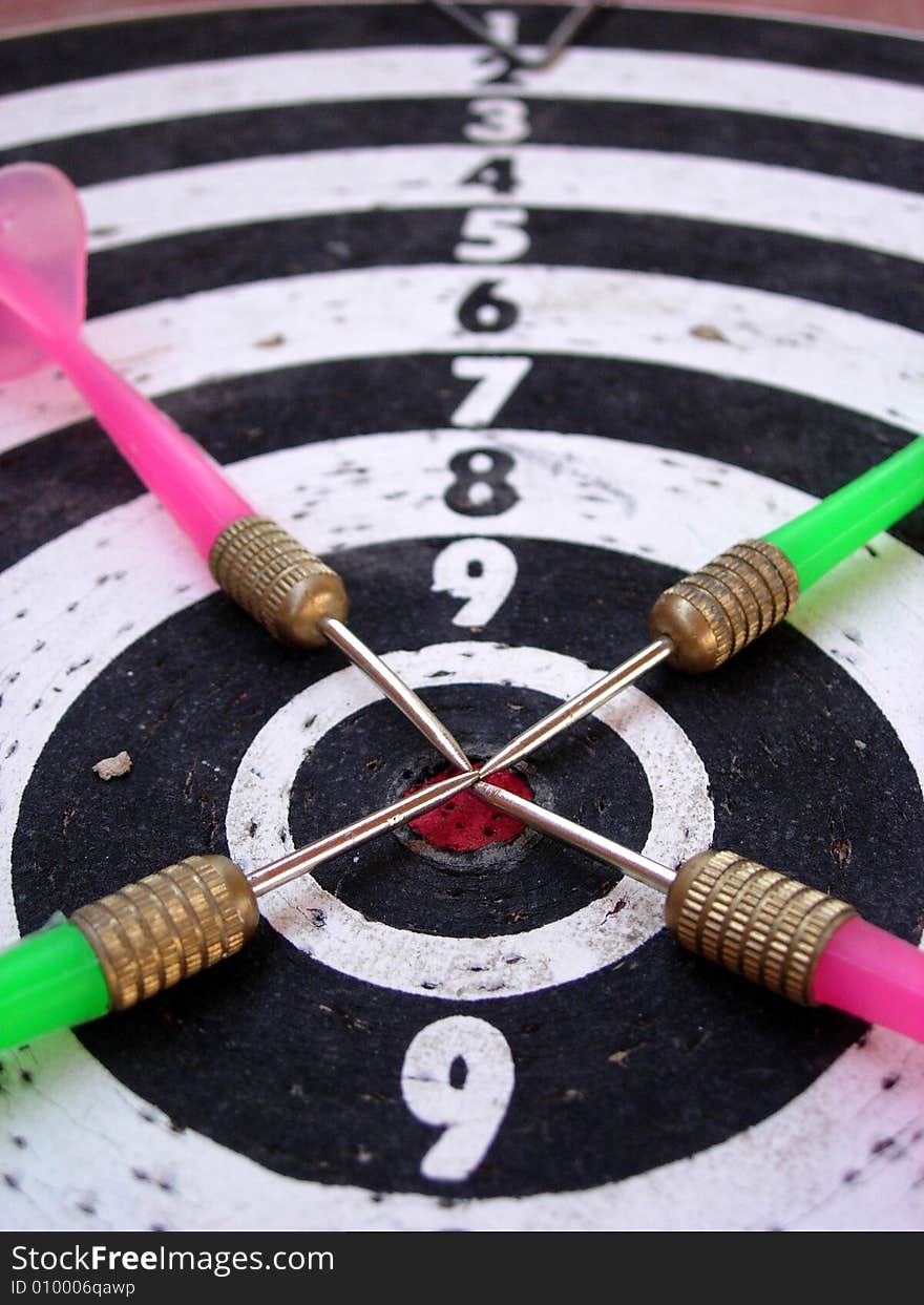 Old dart board - pink and green arrows