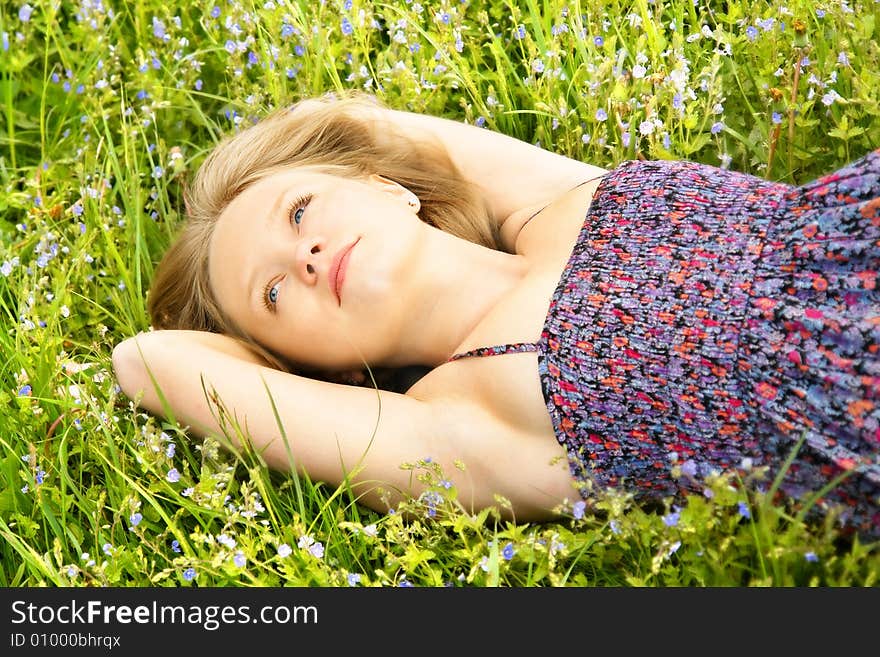 Beautiful thoughtful girl lying on the field of summer flowers. Beautiful thoughtful girl lying on the field of summer flowers