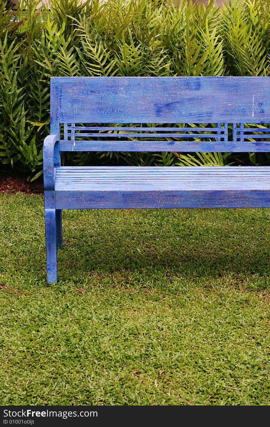 Bright blue painted wooden bench on green grass. Bright blue painted wooden bench on green grass.