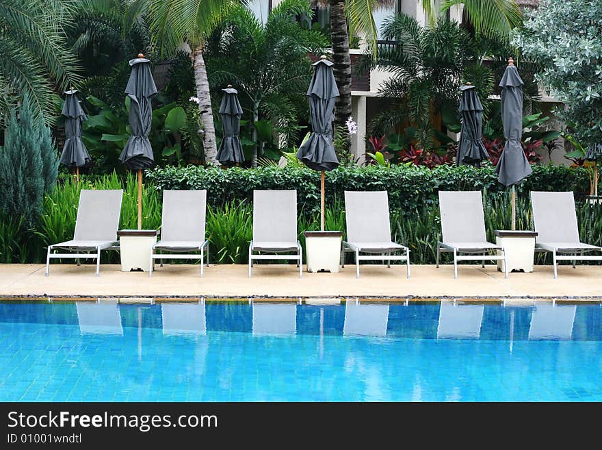 Beautiful swimming pool area with deck chairs.