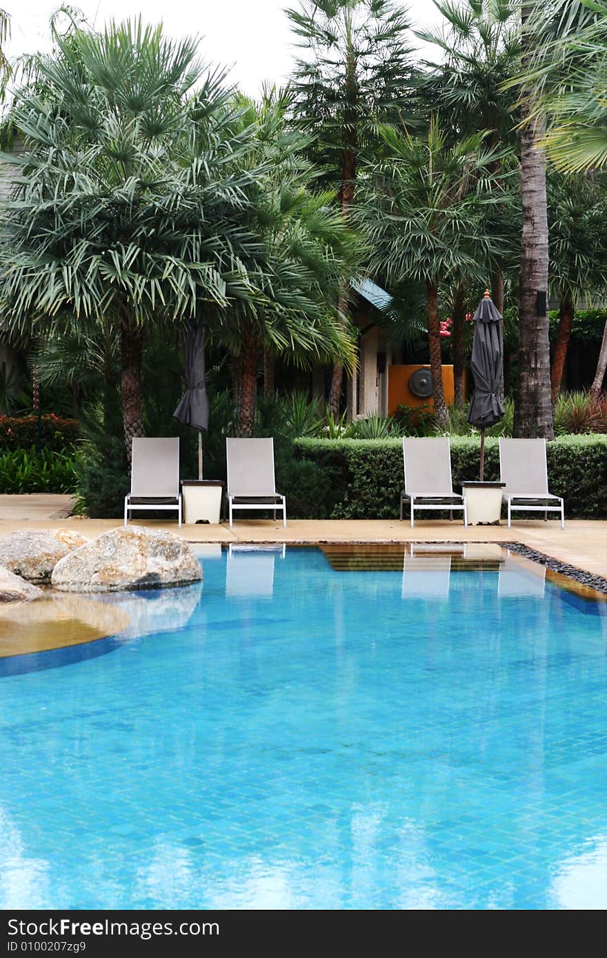 Beautiful swimming pool area with deck chairs. Beautiful swimming pool area with deck chairs.