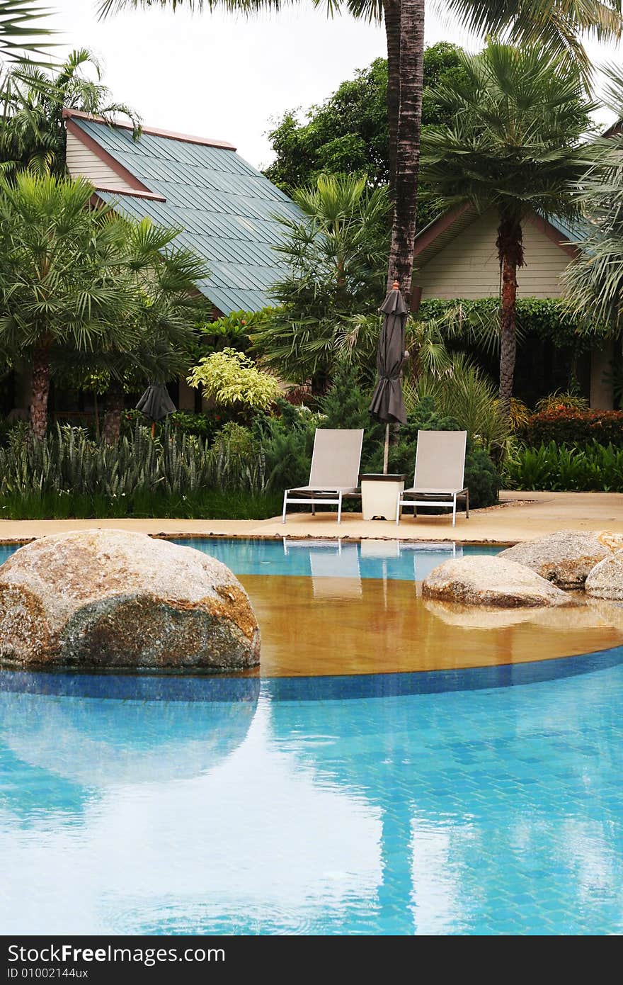 Beautiful swimming pool area with deck chairs.