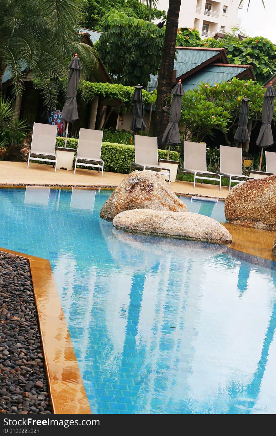 Beautiful swimming pool area with deck chairs.