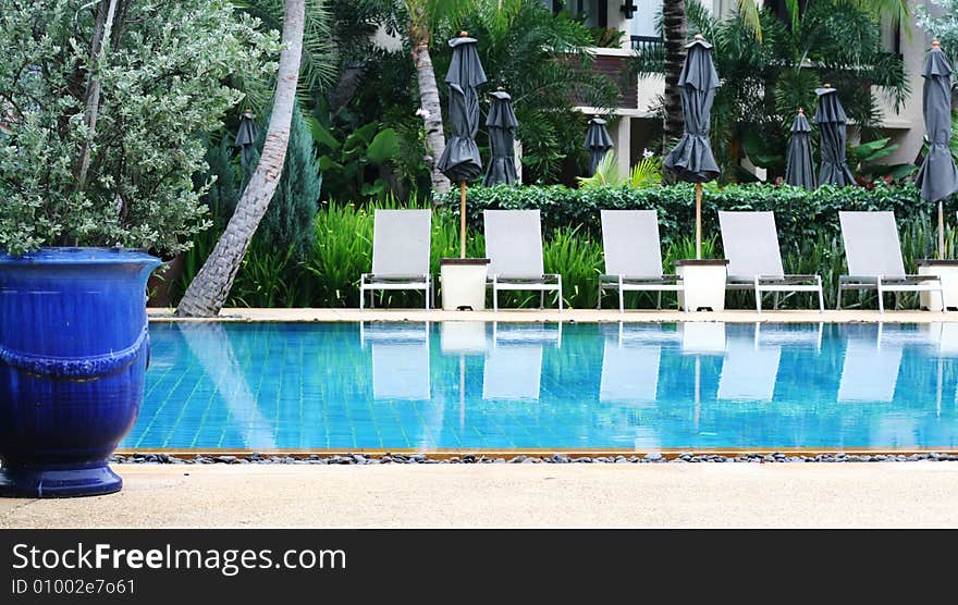 Beautiful swimming pool area with deck chairs.