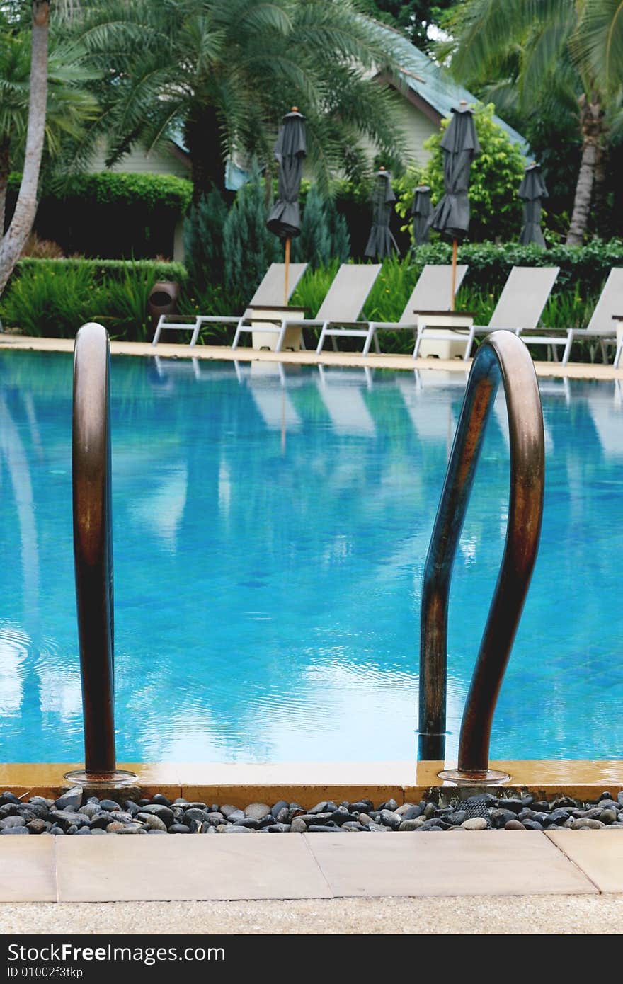 Beautiful swimming pool area with deck chairs.