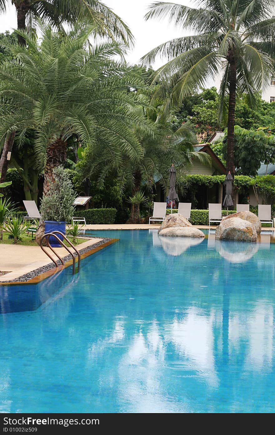 Beautiful swimming pool area with deck chairs.