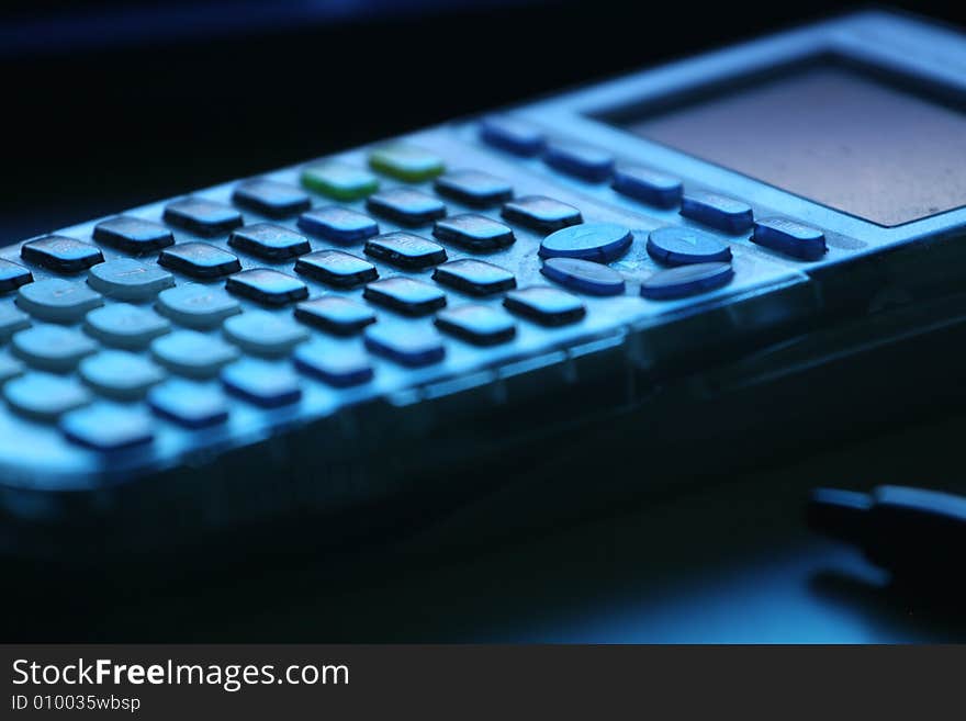 A Calculator and Pen sit on a desk. A Calculator and Pen sit on a desk.