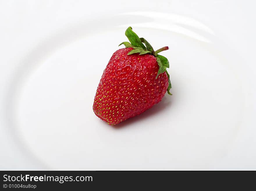 An appetizing strawberry on a white plate. An appetizing strawberry on a white plate