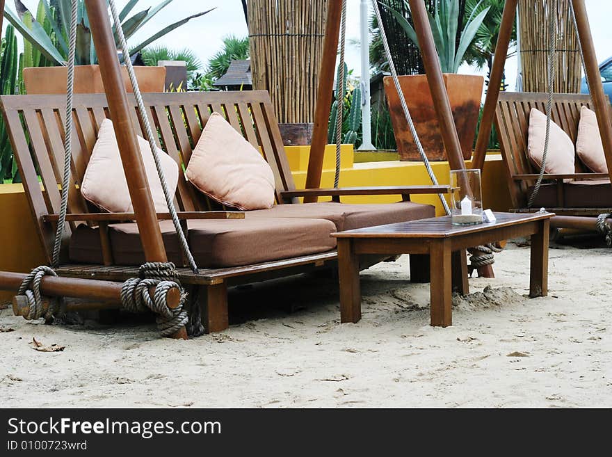 Wooden table and chairs on sand at an outdoor restaurant. Wooden table and chairs on sand at an outdoor restaurant.