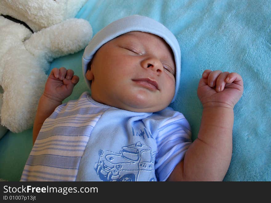 Week old baby boy on a blue blanket early in the morning. Week old baby boy on a blue blanket early in the morning