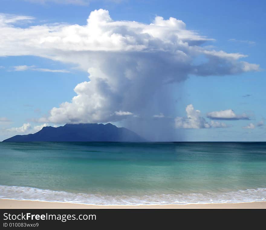 THis is the picture of beautiful clouds with rain over the sea and island on horizon. THis is the picture of beautiful clouds with rain over the sea and island on horizon.