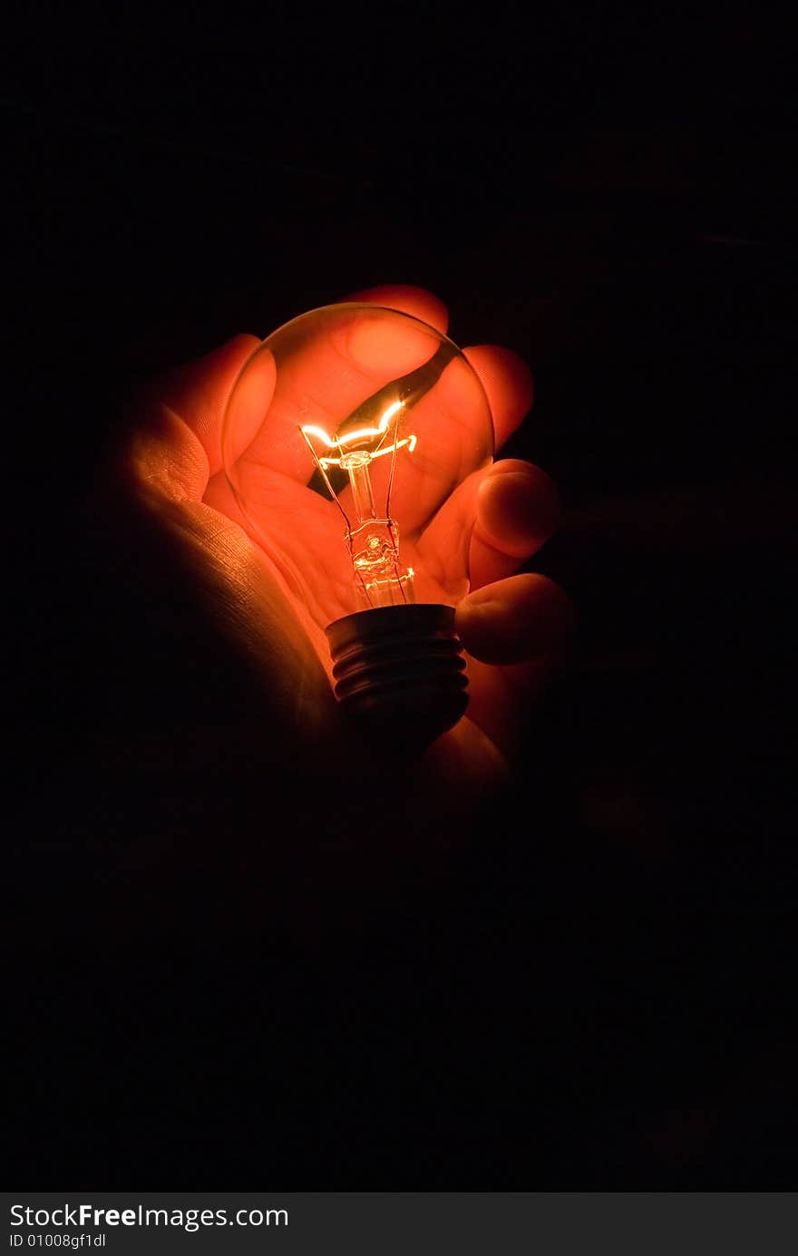 Luminous bulb in hand on black background. Luminous bulb in hand on black background