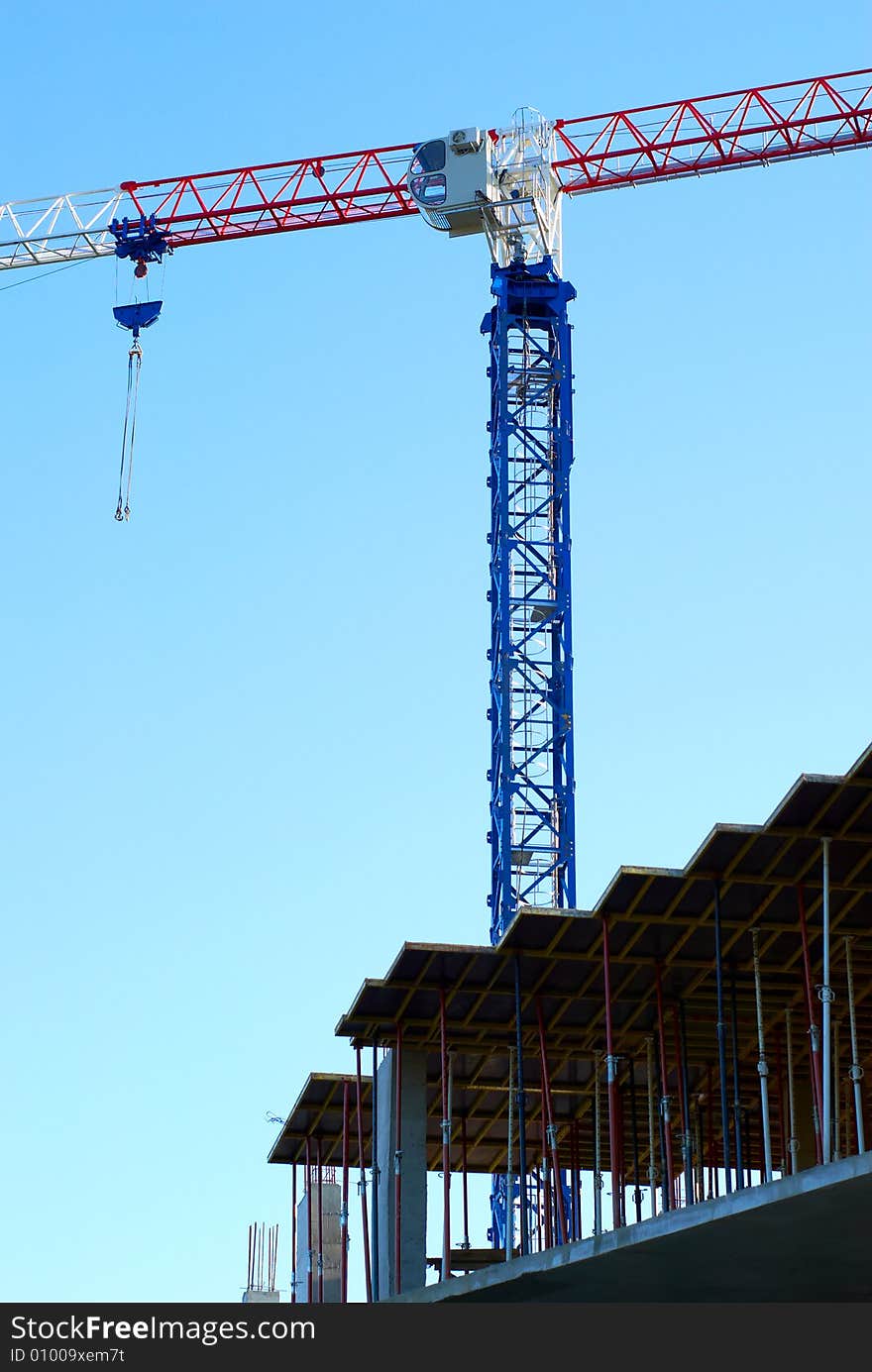 Machine for hoisting heavy materials on background a sky. Machine for hoisting heavy materials on background a sky