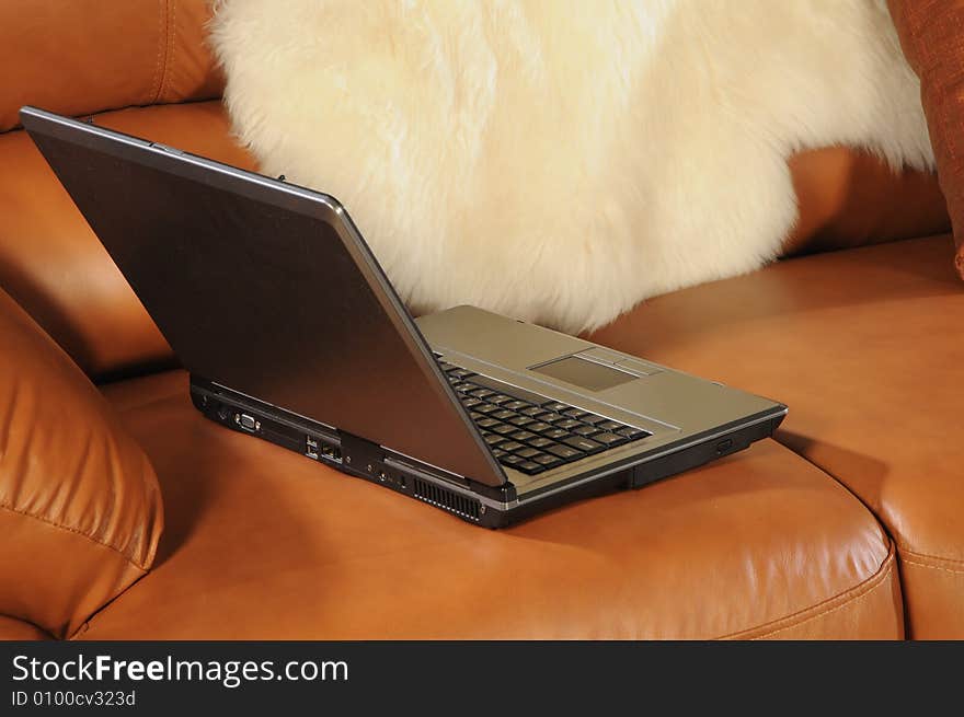 Close up pc on brown leather sofa. Close up pc on brown leather sofa