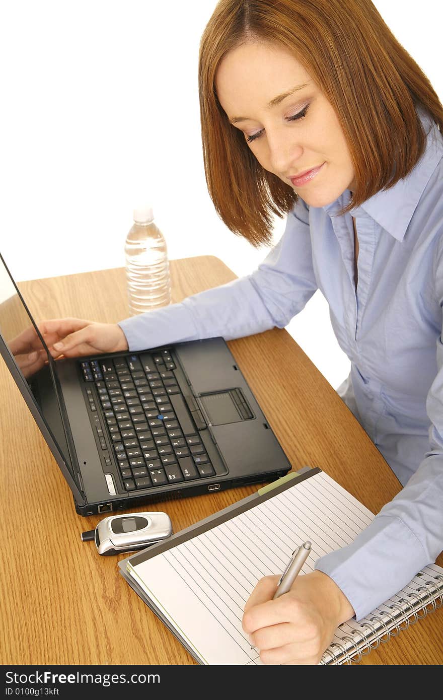 Young woman in laptop using computer and taking note, shot from top. Young woman in laptop using computer and taking note, shot from top