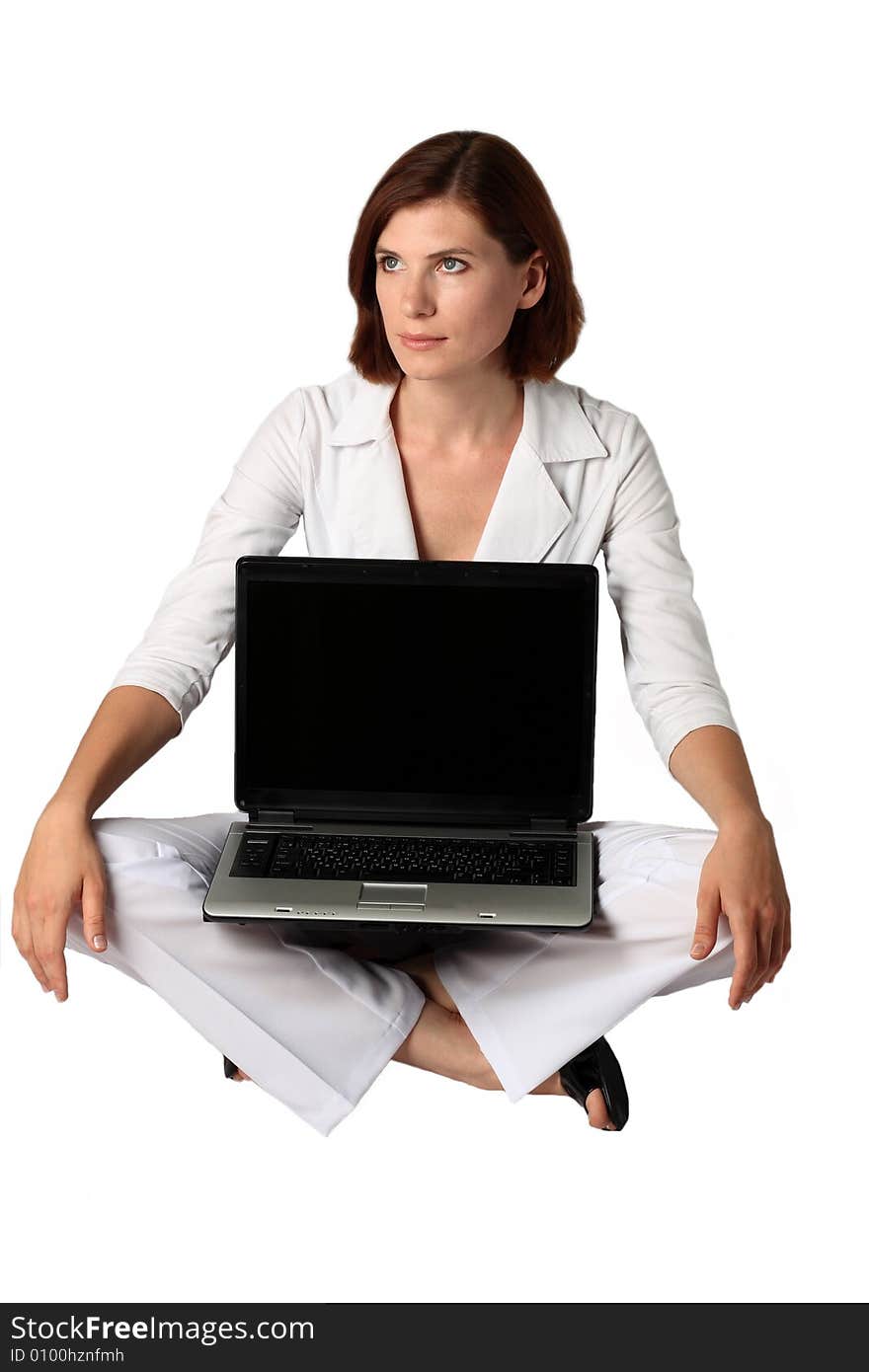 Businesswoman in white clothes sits near a laptop on a floor