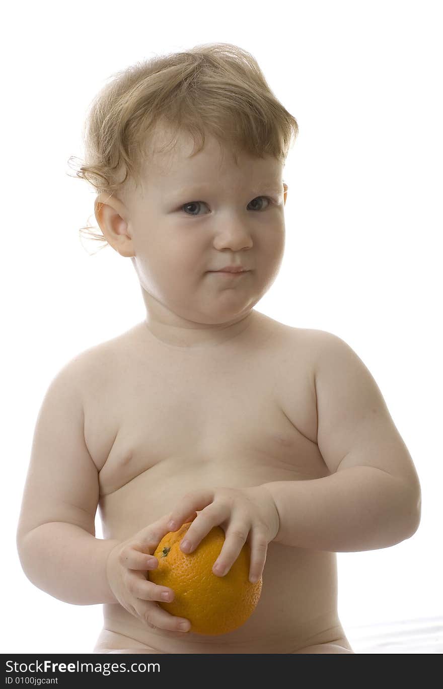 Little toddler holds big orange. Little toddler holds big orange