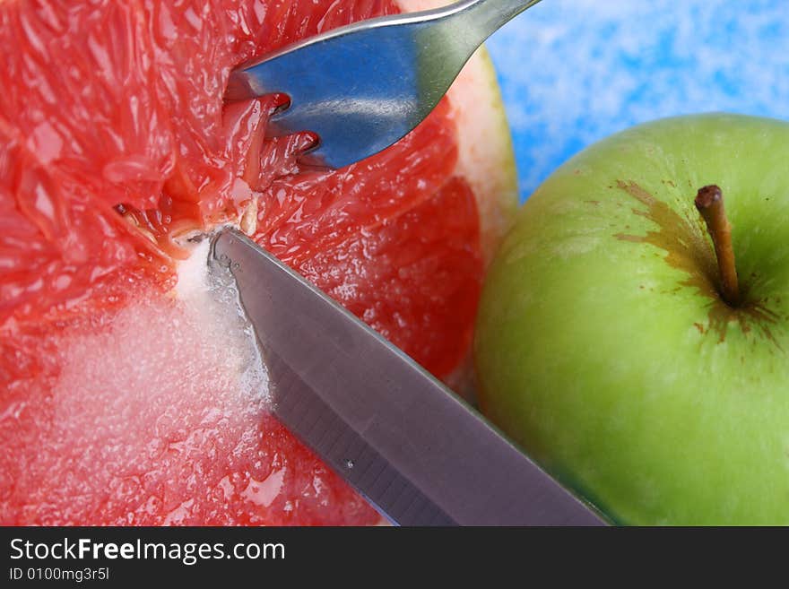 Sliced Pomelo with Sugar and a knife, fork and apple. Sliced Pomelo with Sugar and a knife, fork and apple