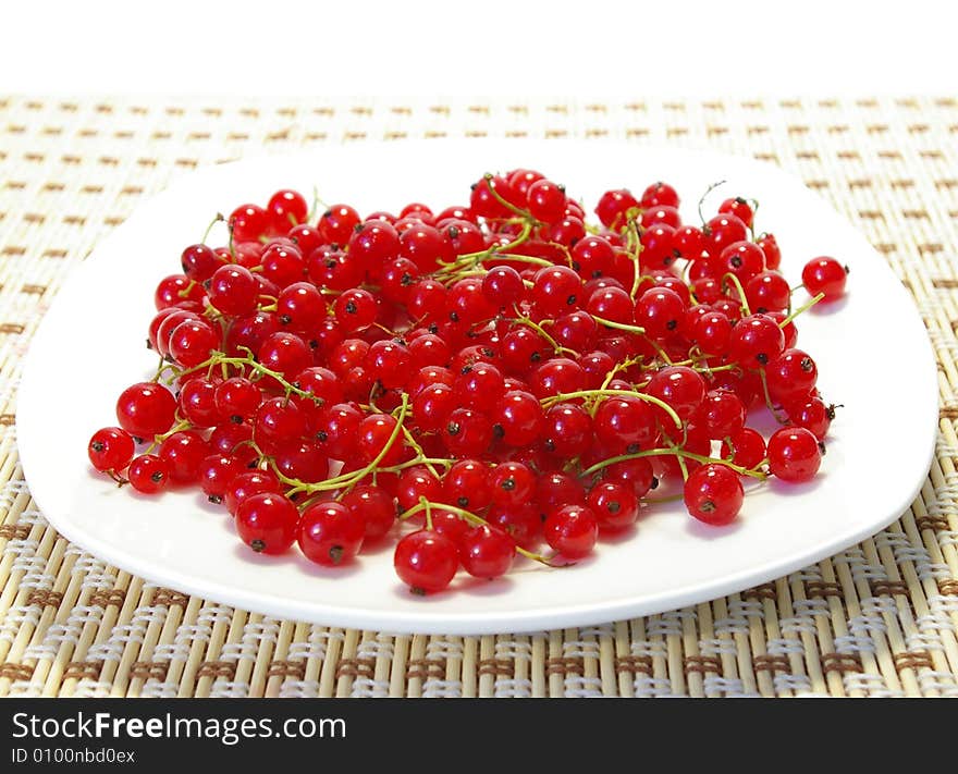 Red and black currant on a white plate. Red and black currant on a white plate