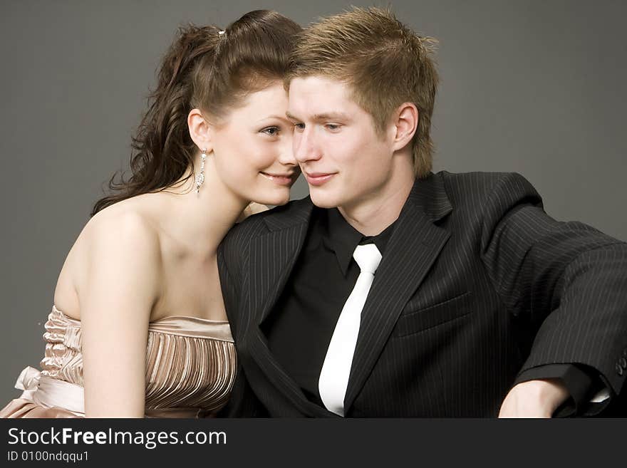 Portrait of a young beautiful couple on gray background