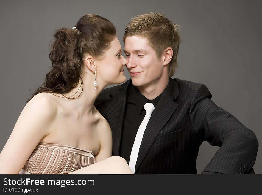 Portrait of a young beautiful couple on gray background