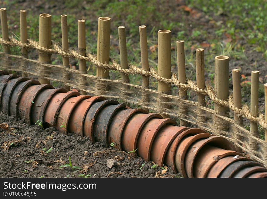 Garden fence of bamboo and earthen pots