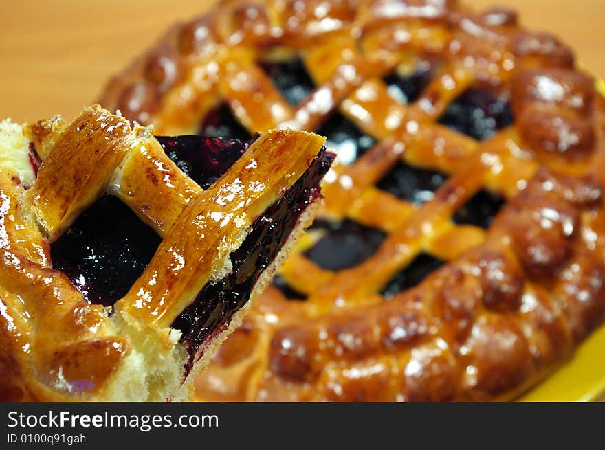 Fresh sweet pie with bilberry on a yellow plate. Fresh sweet pie with bilberry on a yellow plate