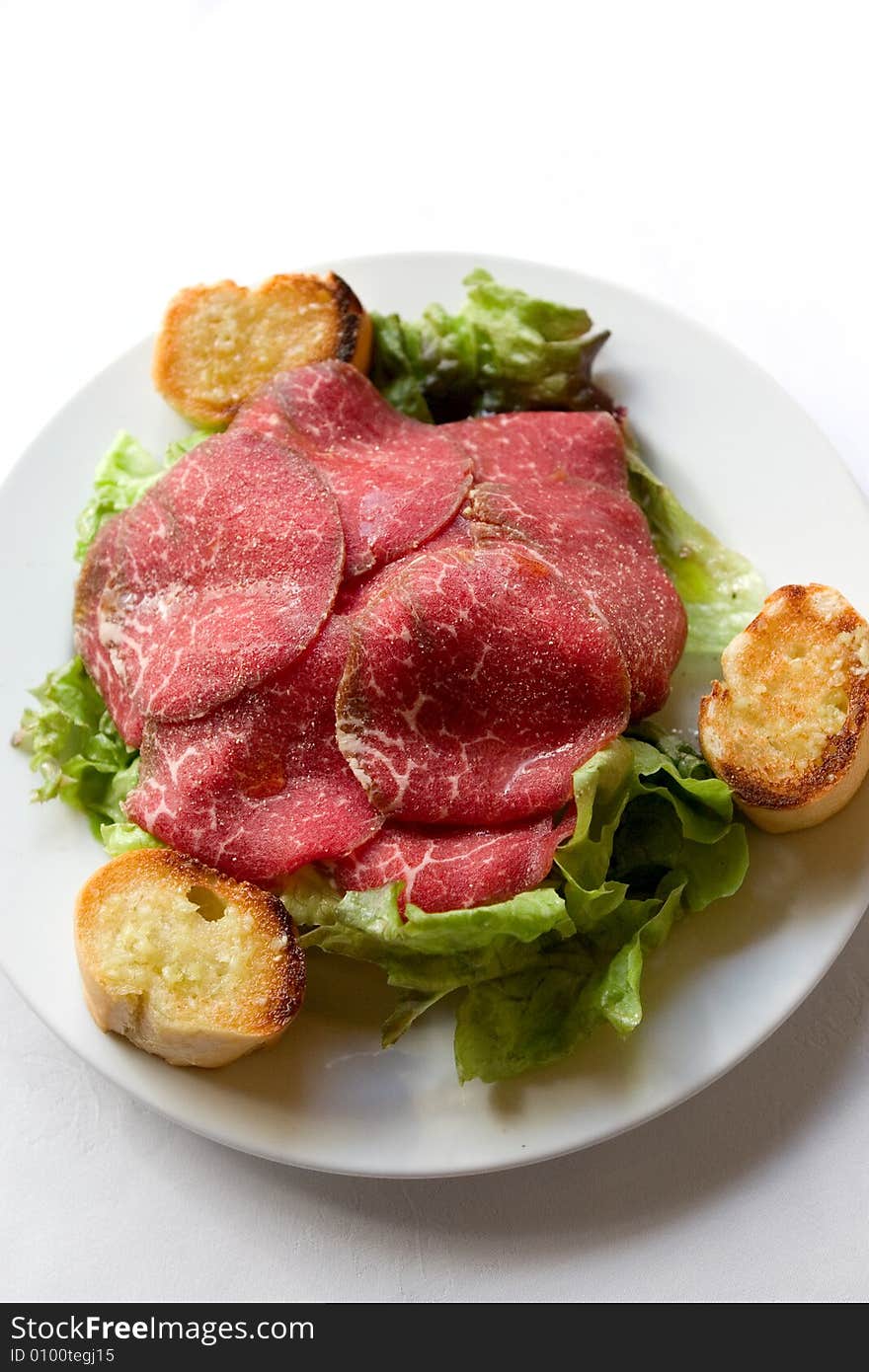 Dry-cured  ham with salad and bread.