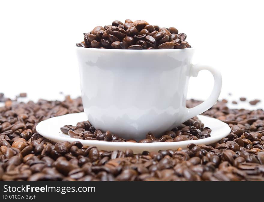 The cup full of coffee beans isolated at the white background