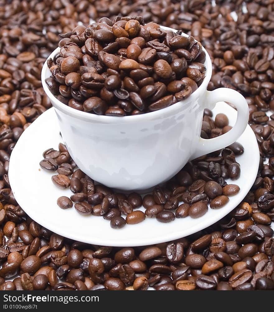 The cup full of coffee beans isolated at the white background